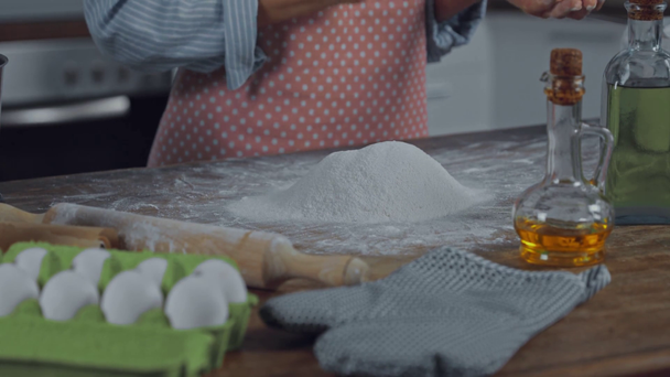 Обрезанный вид женщины, делающей тесто на кухонном столе  - Кадры, видео