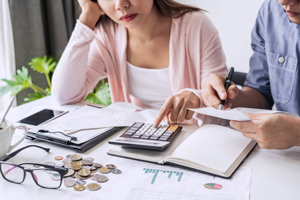 Stressed young couple calculating monthly home expenses, taxes, bank account balance and credit card bills payment, Income is not enough for expenses. - Foto, Bild