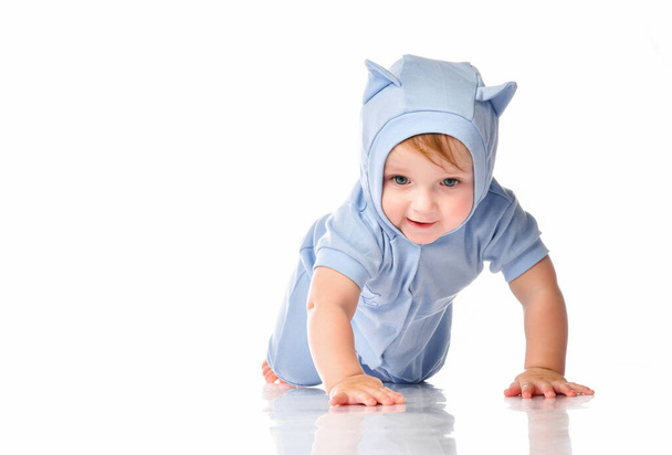 Baby wearing funny suit crawling on studio floor - 写真・画像