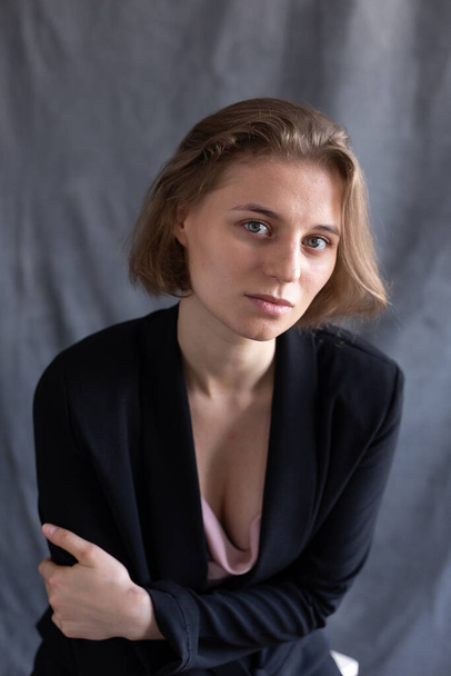 portrait of young caucasian woman with short hair posing in black suit jacket - Foto, immagini