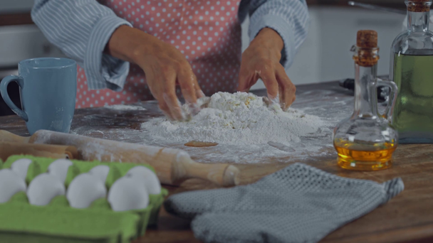 Vista ritagliata della donna che fa la pasta vicino agli ingredienti sul tavolo  - Filmati, video