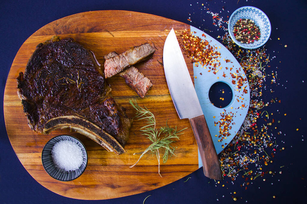 Steak de boeuf sur la planche de bois, sel, poivre et romarin. - Photo, image