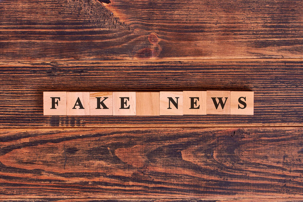 Fake news word written on wood block. Media technology and modern lifestyle concept - Фото, зображення