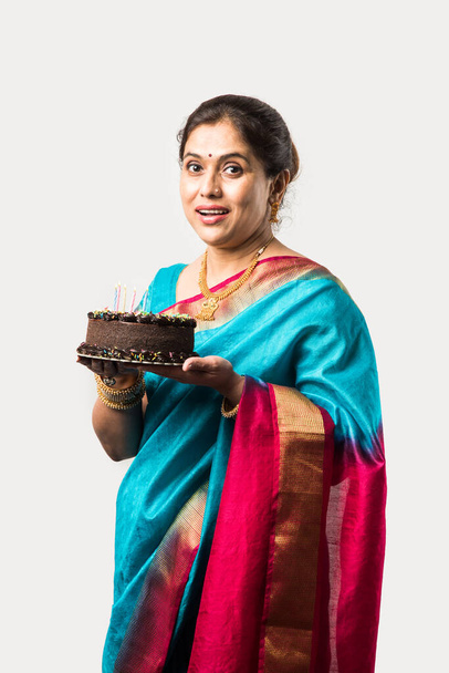 Indiana bela velha mulher ou senhora comemorando aniversário com bolo de chocolate enquanto vestindo roupas étnicas - Foto, Imagem