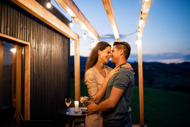 Young couple dancing outdoors at dusk, weekend away in container house in countryside. - Fotografie, Obrázek