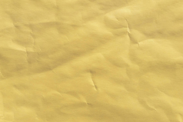 Yellow heavy crumpled paper background, texture of brown wrinkled of old vintage paper, creases on the surface of paper - Fotoğraf, Görsel