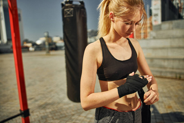 Cropped shot of beautiful fit young woman who is going to training kickboxing on the sports ground - Foto, afbeelding