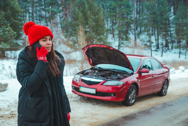 冬の高速道路で壊れた車の助けを求める女性が道端で止まり - 写真・画像