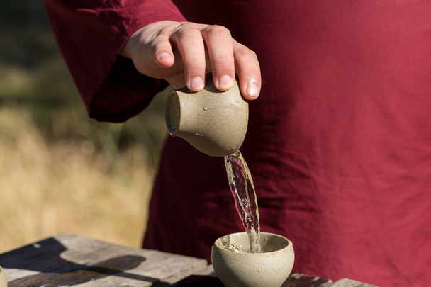 Китайская чайная церемония. Керамический чайник из глины и миски на деревянном фоне. - Фото, изображение