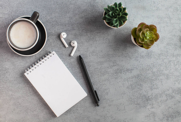 White Notepad, wireless headphones, coffee mug. The concept of online training, work from home, home office. Copy space. High quality photo - 写真・画像