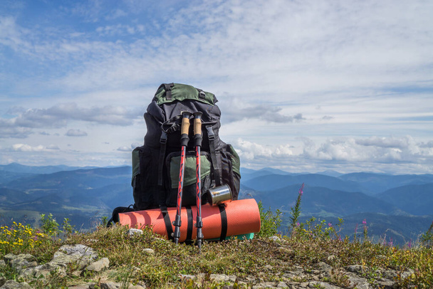 Tourist backpack on the background of mountains and cloudy sky. - Photo, Image