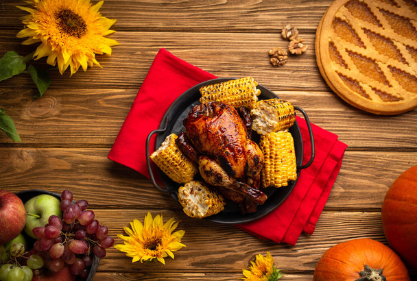 Thanksgiving festive table composition with roasted turkey, pumpkin pie, autumn fruit. Thanksgiving celebration dinner with traditional meals on rustic wooden table. Fall concept, top view . - Foto, afbeelding
