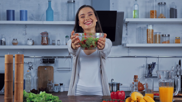 Vrouw met kom salade in de keuken  - Video