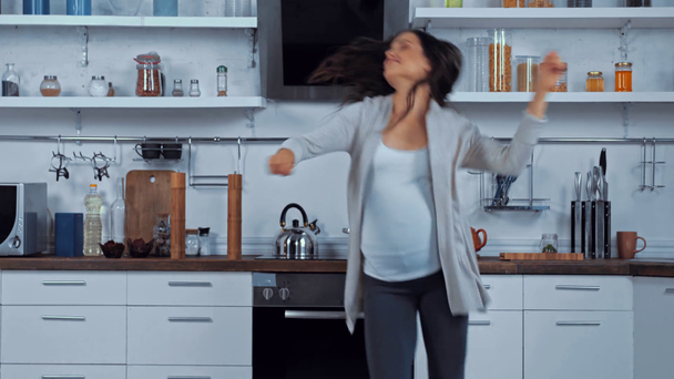 Terhes nő táncol a konyhában  - Felvétel, videó