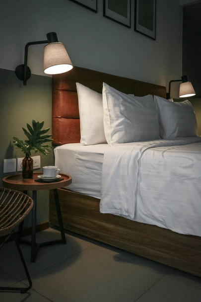 Białe poduszki, kołdra i poszewka na kołdrę na łóżku i stoliku nocnym - Zdjęcie, obraz