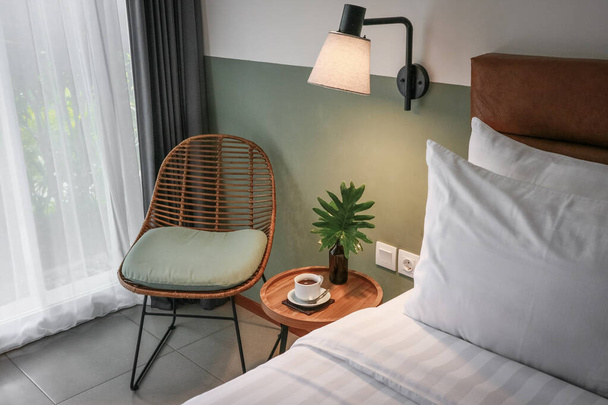 White pillows, duvet and duvet case on a bed and bedside table - Foto, Imagem