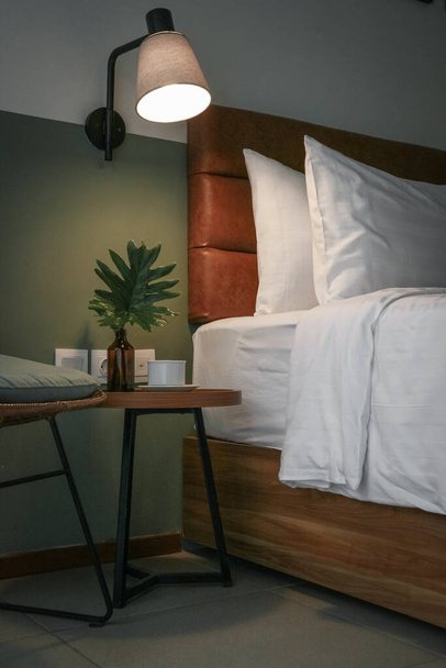 White pillows, duvet and duvet case on a bed and bedside table - Foto, imagen