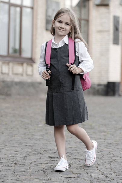 Classy and elegant. Little kid in uniform carry school bag. Back to school supplies. Fashion schoolwear. Uniform dress. Formal education. September 1. Timeless look. Retro style, vintage filter - Foto, immagini