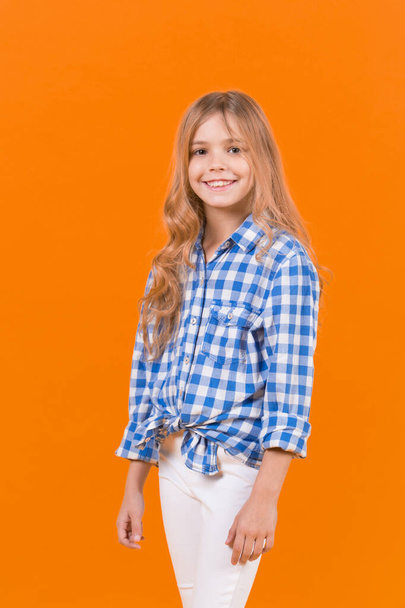 Girl in blue plaid shirt on orange background - Foto, Imagem