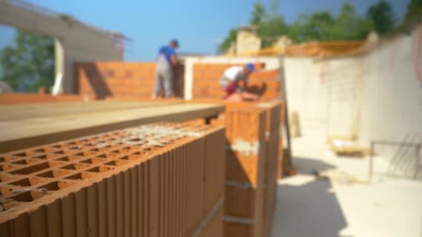 CLOSE UP, DOF : Blurry shot of contractors laying bricks and building walls. - Séquence, vidéo