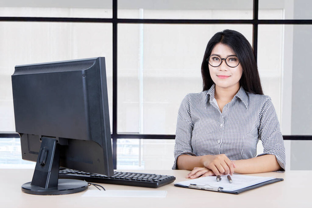 Portrait of pretty businesswoman looks confident and smiling at the camera while working in the office - Фото, зображення