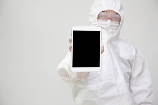 Asijské zdravotní sestra nebo lékař v osobní ochranné prostředky nebo oblek uniforma držení tablet izolované na bílém pozadí - Fotografie, Obrázek