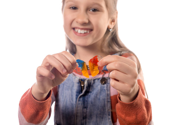 Portrait of little girl with orthodontics appliance isolated on white background. - Fotó, kép
