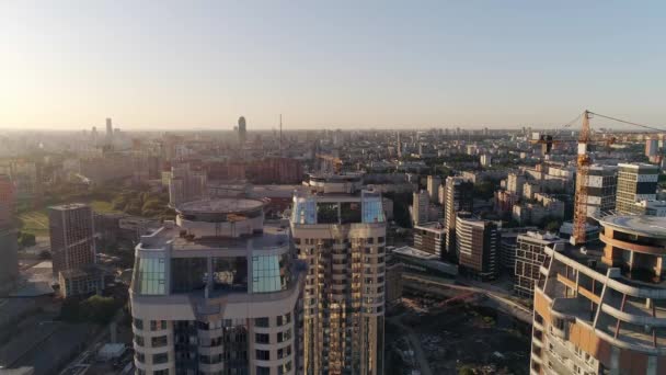 Aerial view of Multi-storey buildings in the city. People on the roof and party. Some houses have been built, one house is still under construction. There are helipads on the rooftops. Cars drive on the roads. - Imágenes, Vídeo