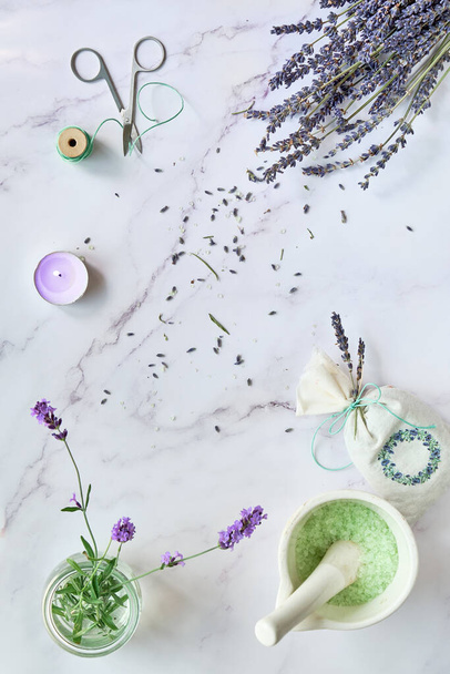 Lavender flowers, both fresh and dry. Flat lay on light marble. Handmade lavender sachets and homemade bath salts. - Foto, Imagen
