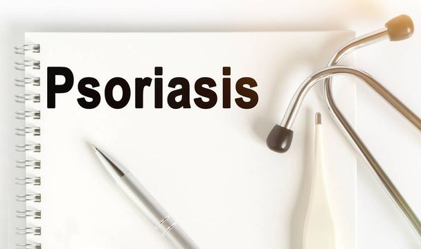 On the table are a stethoscope, a thermometer, a pen and a notebook with the inscription -Psoriasis. The concept of medicine. - Foto, Imagem