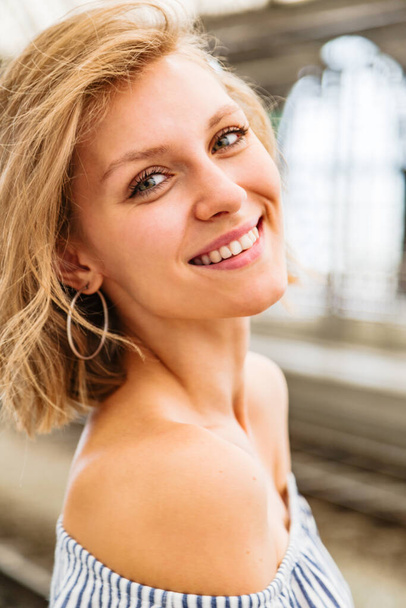 Portrait of smiling blonde woman standing in half-turn - Valokuva, kuva