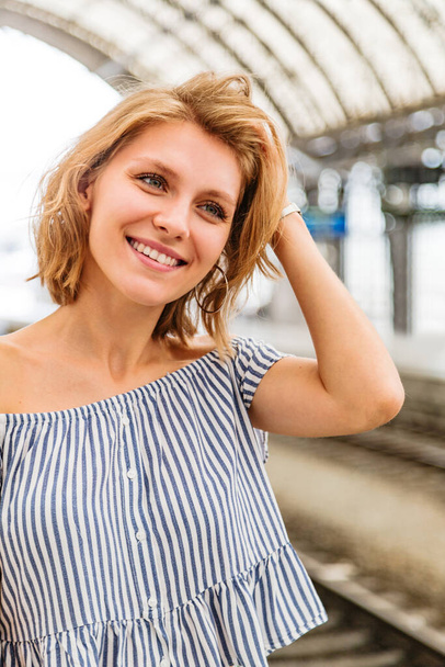 Girl straightens her hair and standing on a train platform - Foto, Bild