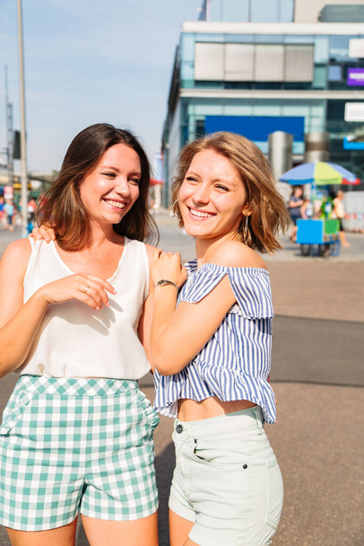 Two young girlfriends walk in city in summer day - Foto, Bild