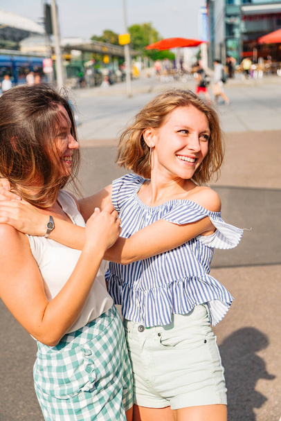 Two young girlfriends walk in city in summer day - Fotografie, Obrázek
