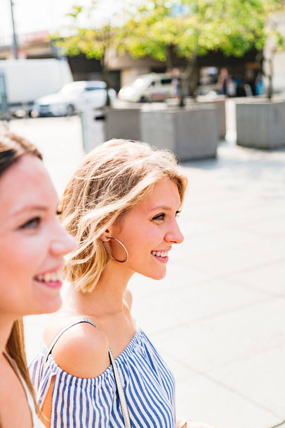 Two smiling women walking on summer sunny day - Foto, afbeelding