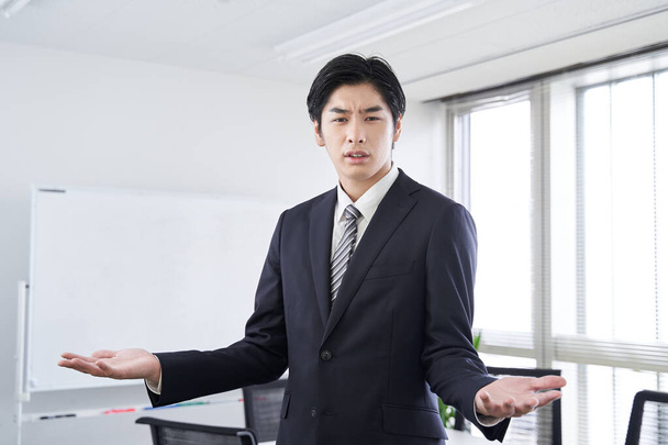 Ein japanischer Geschäftsmann diskutiert in einem Konferenzraum - Foto, Bild