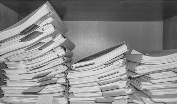 Paperiset asiakirjat arkistossa. Arkistohuoneen hyllyillä on asiakirjoja. Toimiston hyllyt kaapissa täynnä tiedostoja. mustavalkoinen kuva - Valokuva, kuva