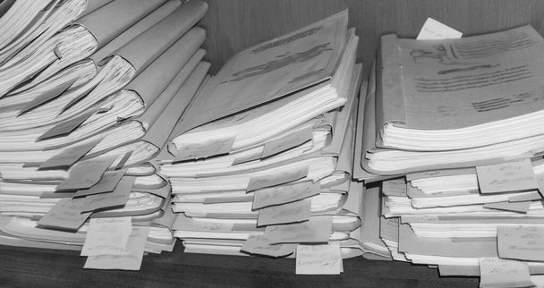 Паперові документи, складені в архіві. Документи на полицях архівної кімнати. Офісні полиці в шафі заповнені файлами. чорно-біле фото
 - Фото, зображення
