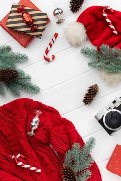 Boże Narodzenie zakupy makieta ze swetrem, prezenty i ozdoby na drewnianym tle. Widok z góry płaski świecki szablon powitania zaproszenia - Zdjęcie, obraz