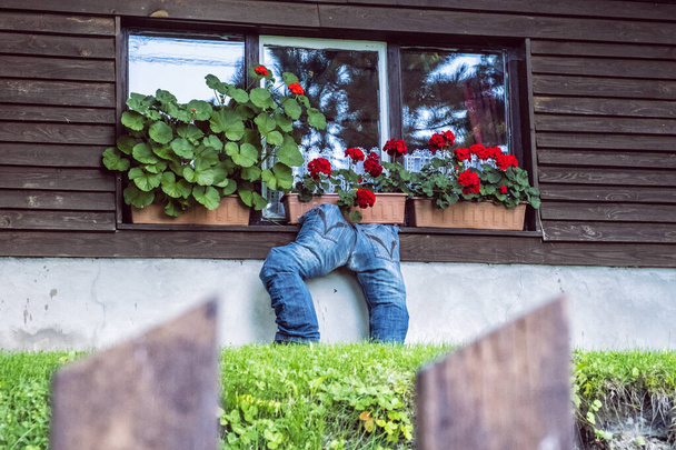 Вікно з квітами і смішними джинсами, гірське село Кордікі, пагорби Кремніки, Словацька республіка. - Фото, зображення