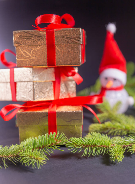Ünnepi karácsonyi dekoráció egy hóember és csomagolt ajándékok piros szalaggal. - Fotó, kép