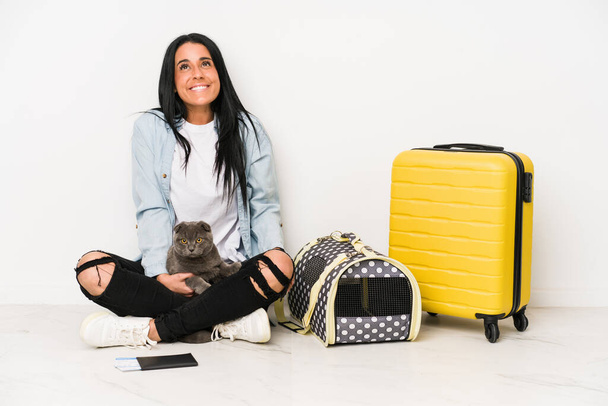 Traveler woman with her cat isolated on white background dreaming of achieving goals and purposes - Photo, Image