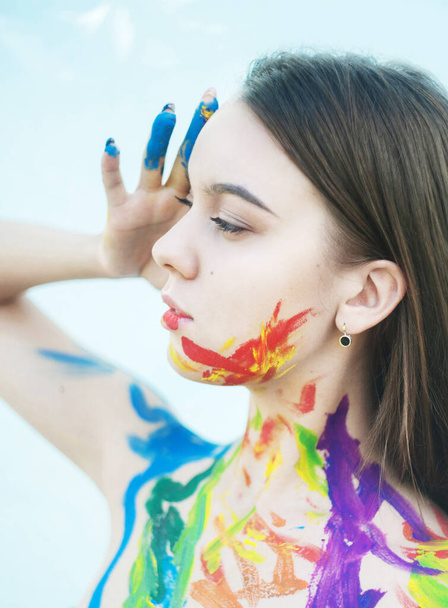 Close up portrait of young woman with paints on the face - Foto, imagen