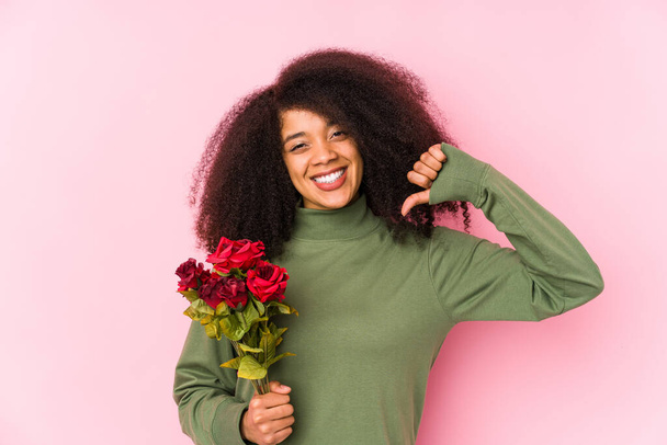 Junge Afro-Frau hält eine Rosen isoliert Junge Afro-Frau hält eine Rose fühlt sich stolz und selbstbewusst, Beispiel zu folgen. - Foto, Bild