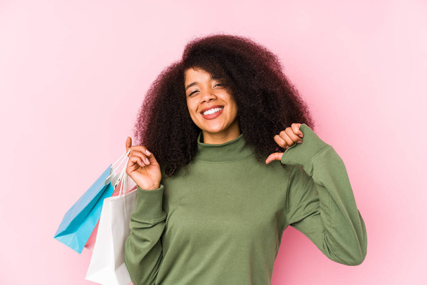 Young afro woman shopping isolated Young afro woman buying isolaYoung afro woman holding a roses isolated feels proud and self confident, example to follow - Fotó, kép
