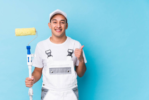 Young professional painter latin man isolated smiling and raising thumb up - Фото, зображення