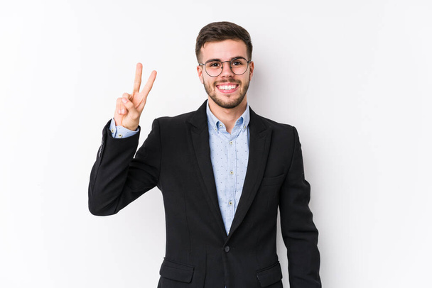 Junger kaukasischer Geschäftsmann posiert isoliert vor weißem Hintergrund Junger kaukasischer Geschäftsmann zeigt Siegeszeichen und lächelt breit. - Foto, Bild