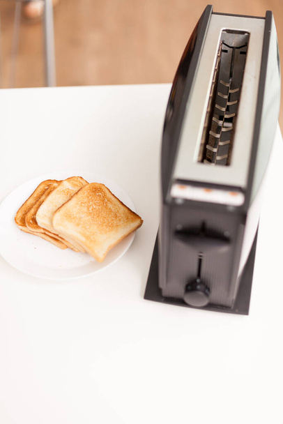 Roasted bread near electric toaster - Photo, Image
