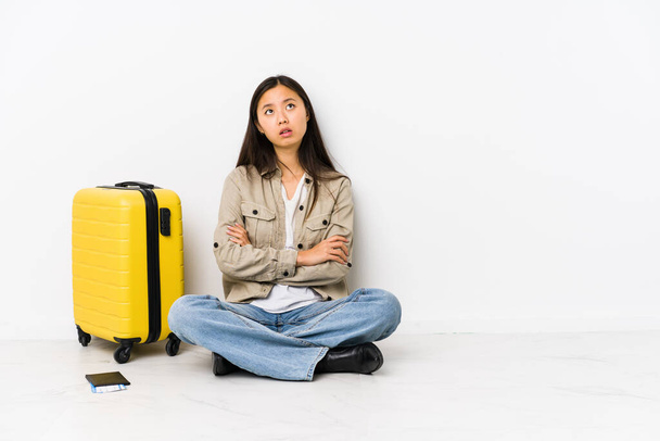 Jeune voyageuse chinoise assise tenant une carte d'embarquement fatiguée d'une tâche répétitive. - Photo, image