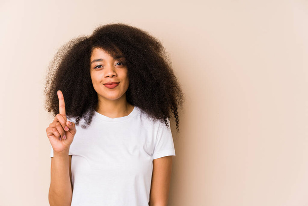 Nuori afrikkalainen amerikkalainen nainen näyttää numero yksi sormella. - Valokuva, kuva